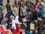 Bupati Azhari didampingi kepala OPD dan camat menyerahkan seragam untuk siswa SD-SMP.